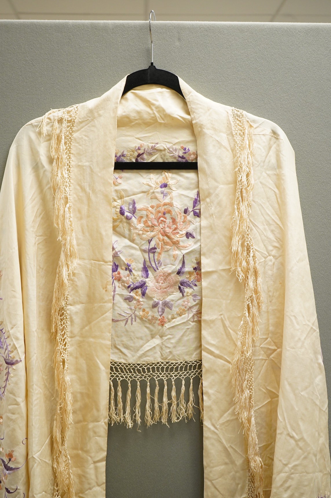 A 19th century Chinese cream silk embroidered and fringed stole, converted to a cape. Embroidered in pastel pinks and lilacs.192cm long